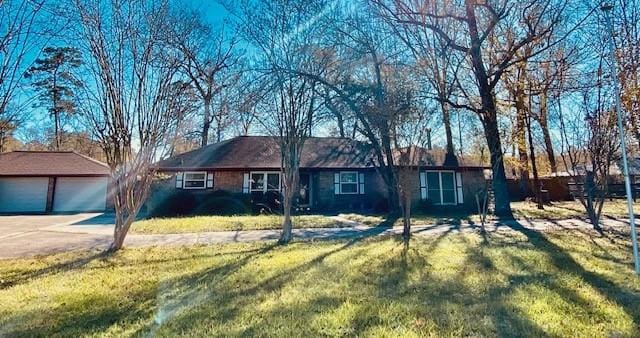 ranch-style home featuring an outbuilding, a front yard, and a garage