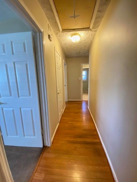 corridor featuring wood-type flooring and a textured ceiling