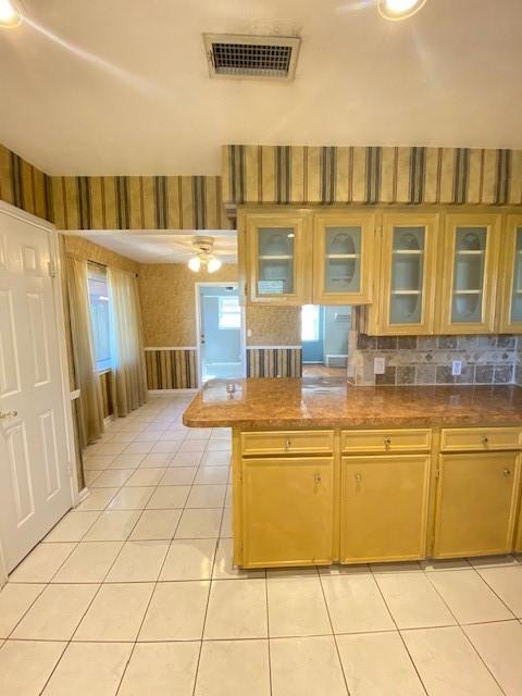 kitchen with light tile patterned flooring and kitchen peninsula