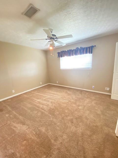 spare room with carpet flooring, ceiling fan, and a textured ceiling