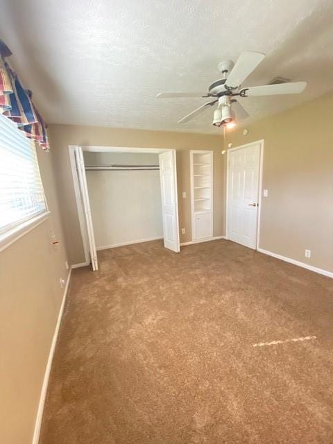 unfurnished bedroom featuring ceiling fan, carpet floors, a textured ceiling, and a closet