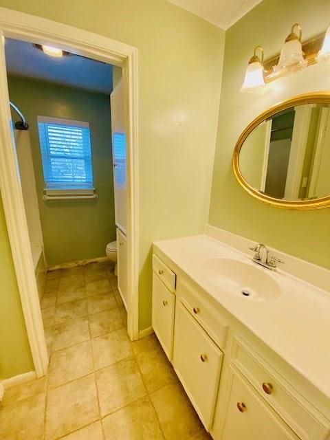 bathroom with tile patterned flooring, vanity, and toilet