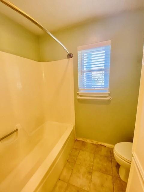 bathroom with bathing tub / shower combination and toilet