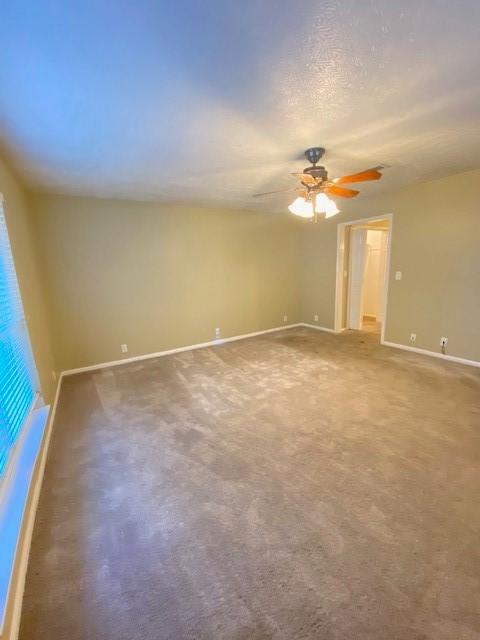 spare room with ceiling fan and carpet