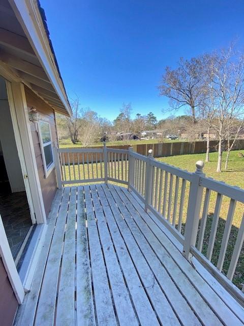 wooden terrace featuring a lawn