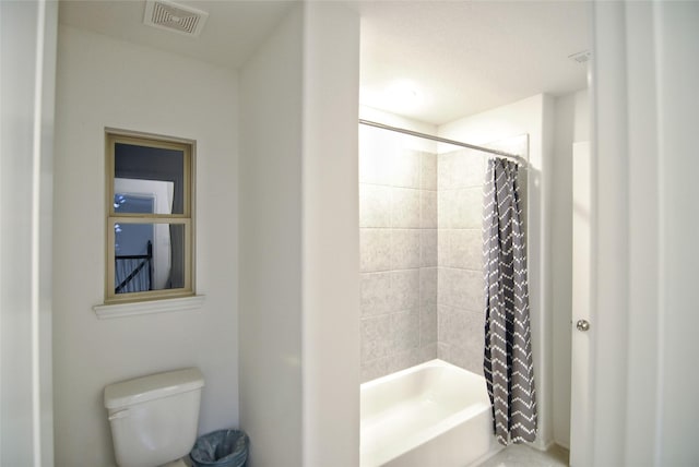 bathroom with shower / bath combination with curtain and toilet