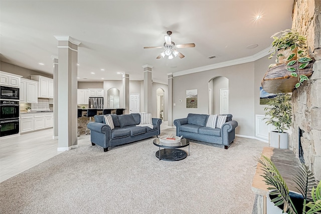 carpeted living room featuring ceiling fan, ornate columns, and crown molding