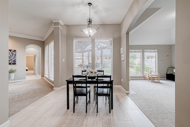 dining room with light colored carpet and ornamental molding