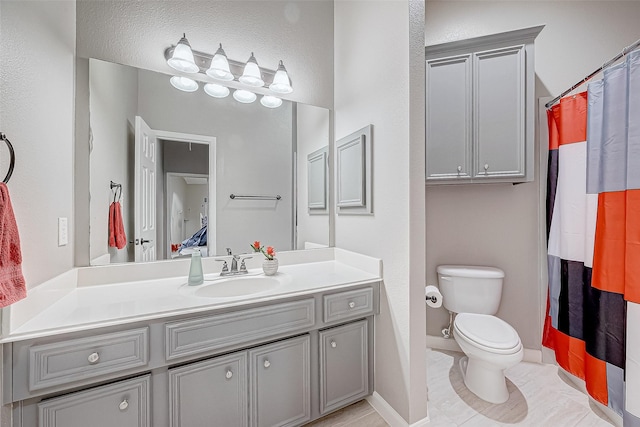 bathroom with tile patterned flooring, vanity, toilet, and walk in shower