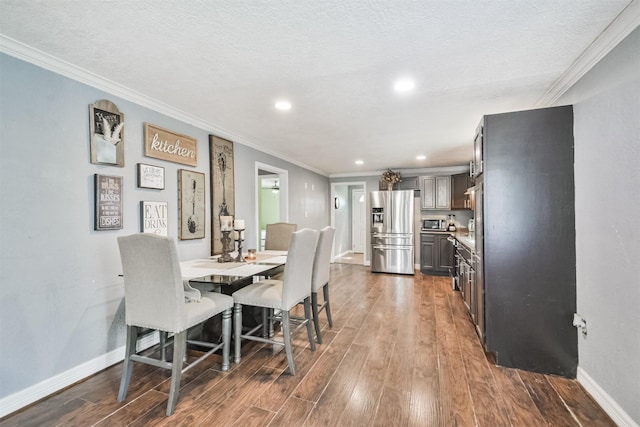 dining room with ornamental molding, a textured ceiling, and dark wood-type flooring