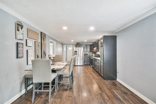 dining room featuring a textured ceiling, crown molding, and dark wood-type flooring