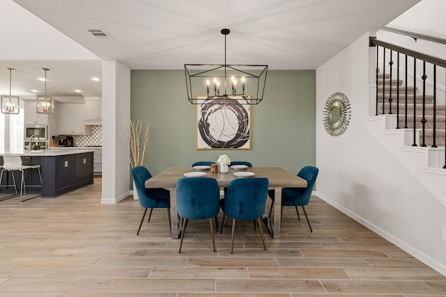 dining room featuring light wood-type flooring and an inviting chandelier