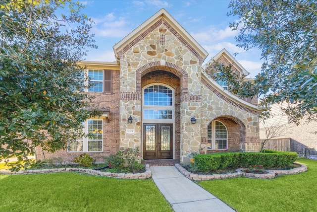 entrance to property featuring a yard and french doors