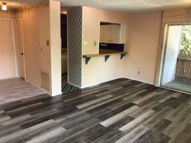 909 Silber Rd Unit 4A, Houston, TX 77024 - interior space featuring baseboards, visible vents, a textured ceiling, and dark wood-type flooring