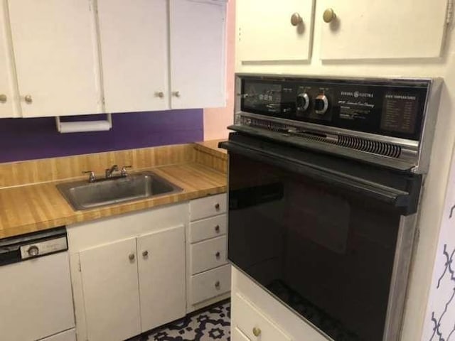 909 Silber Rd Unit 4A, Houston, TX 77024 - kitchen featuring black oven, white cabinetry, a sink, and dishwasher