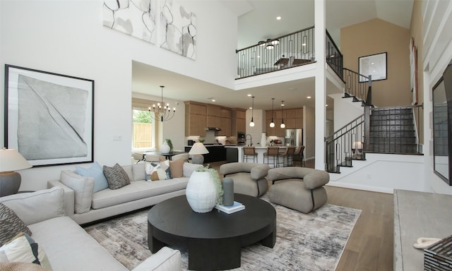 living room featuring a towering ceiling, a chandelier, and dark hardwood / wood-style floors