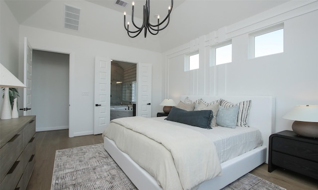 bedroom featuring hardwood / wood-style floors, an inviting chandelier, and ensuite bath