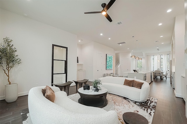 living room featuring ceiling fan and dark hardwood / wood-style floors