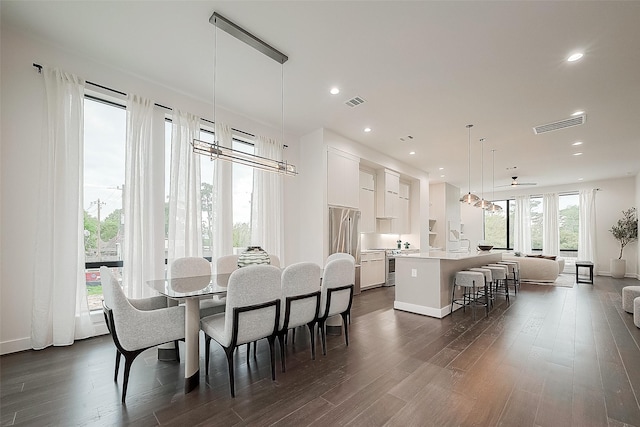 dining room with dark wood-type flooring, ceiling fan, and plenty of natural light