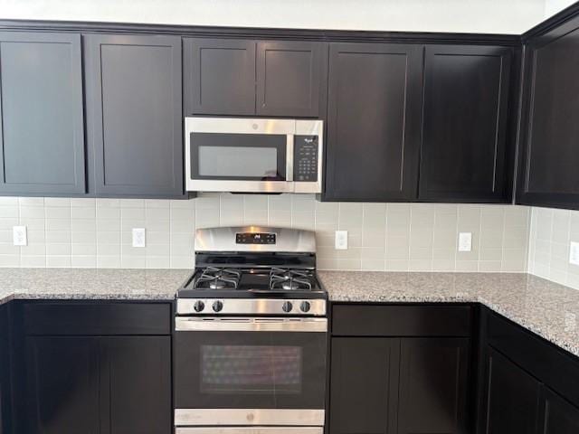 kitchen featuring decorative backsplash, light stone counters, and stainless steel appliances