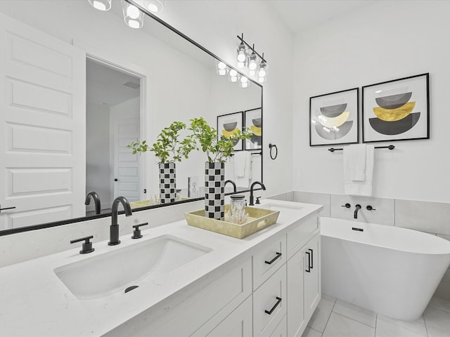 bathroom with a washtub, vanity, and tile patterned flooring