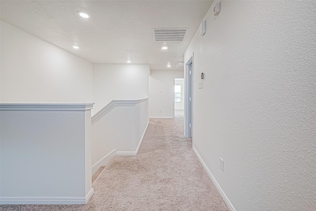 hall featuring light colored carpet