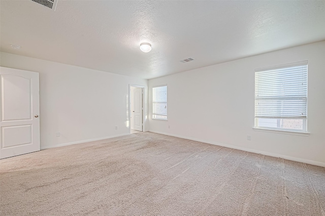 carpeted spare room with a textured ceiling