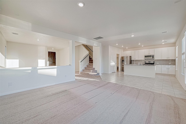 unfurnished living room with light colored carpet