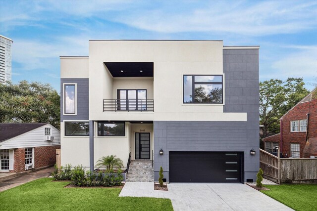 contemporary home with a front yard, a balcony, and a garage