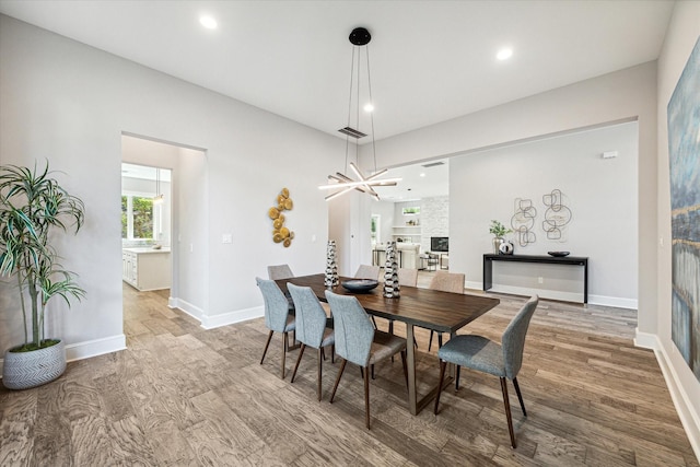 dining space with hardwood / wood-style flooring and a notable chandelier