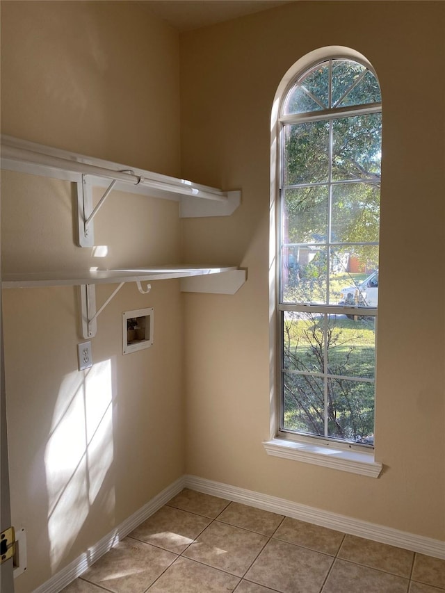 laundry area with washer hookup, plenty of natural light, and light tile patterned flooring