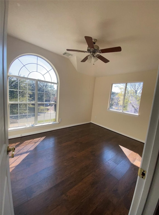 empty room featuring ceiling fan, dark hardwood / wood-style flooring, and vaulted ceiling