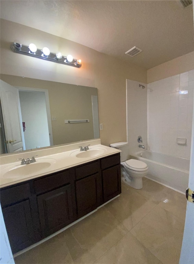 full bathroom featuring vanity, tiled shower / bath combo, and toilet