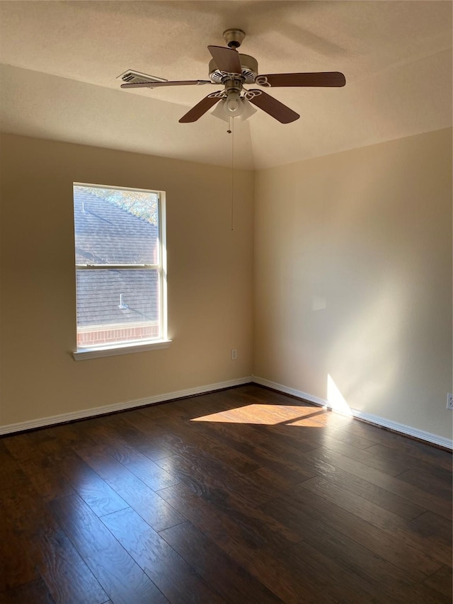 spare room featuring ceiling fan, dark wood-type flooring, and vaulted ceiling