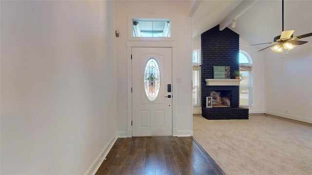 entrance foyer with vaulted ceiling with beams, dark hardwood / wood-style floors, a brick fireplace, and ceiling fan