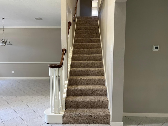 stairs featuring tile patterned flooring, a chandelier, and ornamental molding