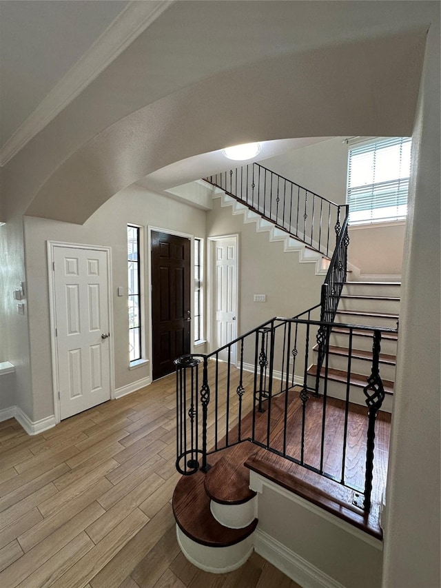 foyer with light wood-type flooring and ornamental molding