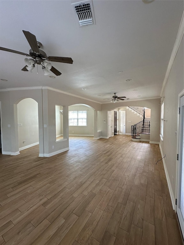 unfurnished living room featuring wood-type flooring, ceiling fan, and crown molding