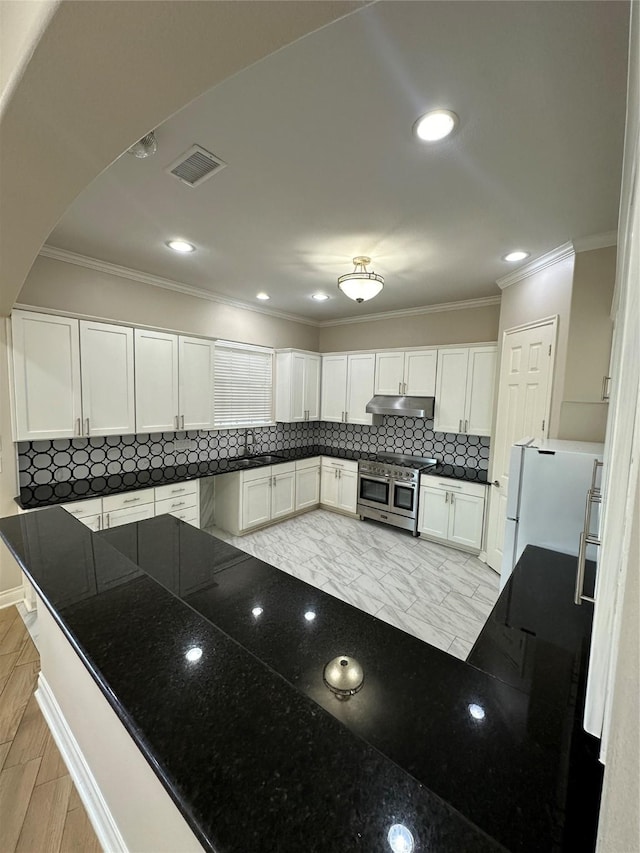 kitchen featuring white cabinetry, tasteful backsplash, kitchen peninsula, white fridge, and range with two ovens