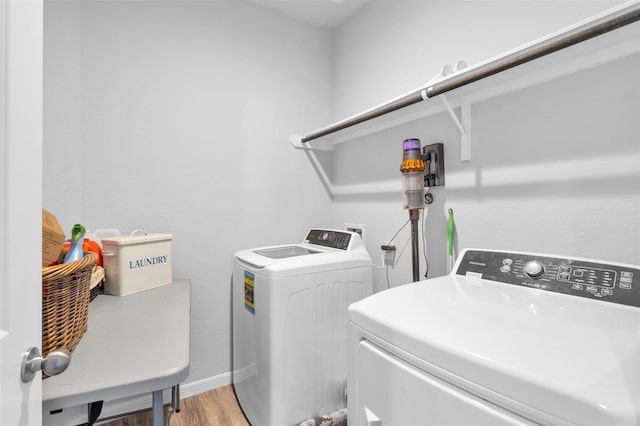 laundry area featuring light hardwood / wood-style floors, sink, and washing machine and clothes dryer