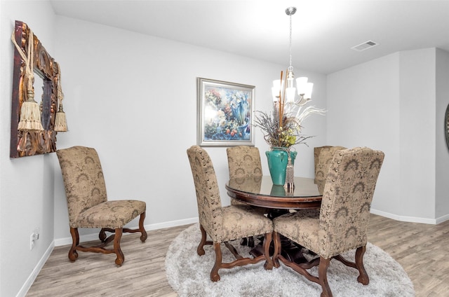 dining space with a chandelier and light wood-type flooring