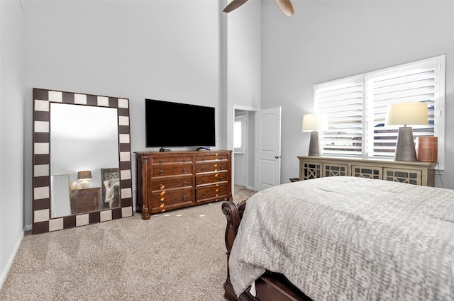 bedroom with carpet flooring, a high ceiling, and ceiling fan