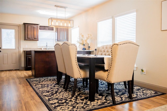 dining area with light hardwood / wood-style floors and sink