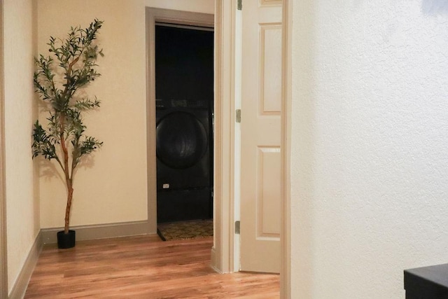 hall with light wood-type flooring and washer / clothes dryer