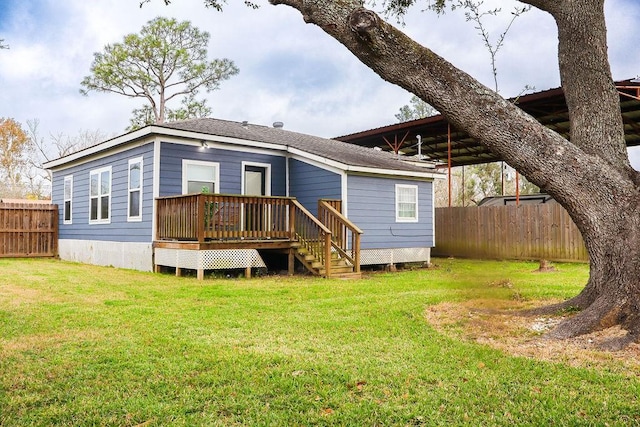 rear view of property with a deck, a carport, and a lawn