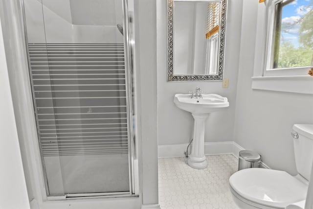 bathroom featuring walk in shower, sink, and toilet