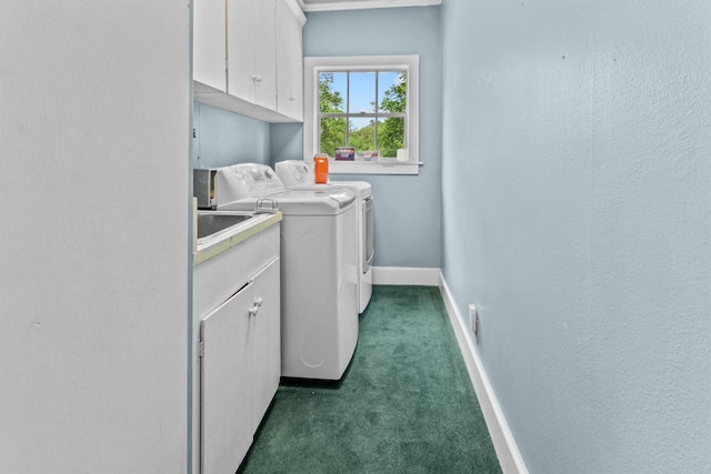 clothes washing area featuring cabinets, washer and clothes dryer, and dark carpet