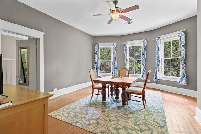 dining room with ceiling fan, a wealth of natural light, and light hardwood / wood-style flooring