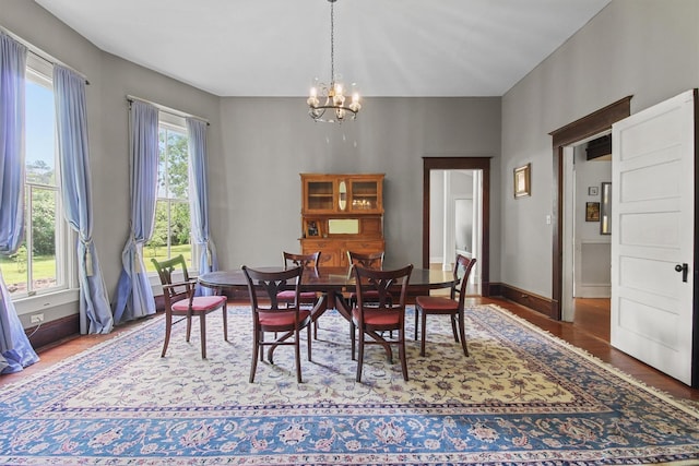 dining area with dark hardwood / wood-style floors and a notable chandelier