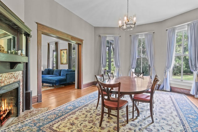 dining area with light wood-type flooring and an inviting chandelier